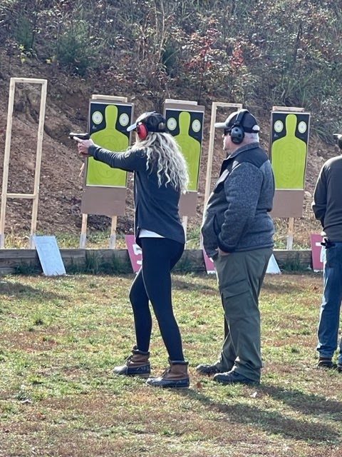 An instructor coaching a student through live-fire practice on the range